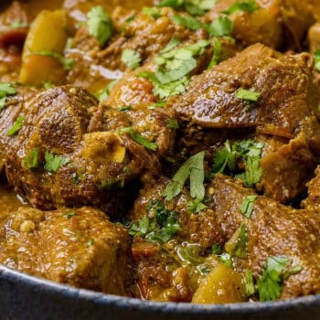 Ainsley Harriott Curry Goat, rich Jamaican stew with tender goat meat, golden curry sauce, and fresh coriander.